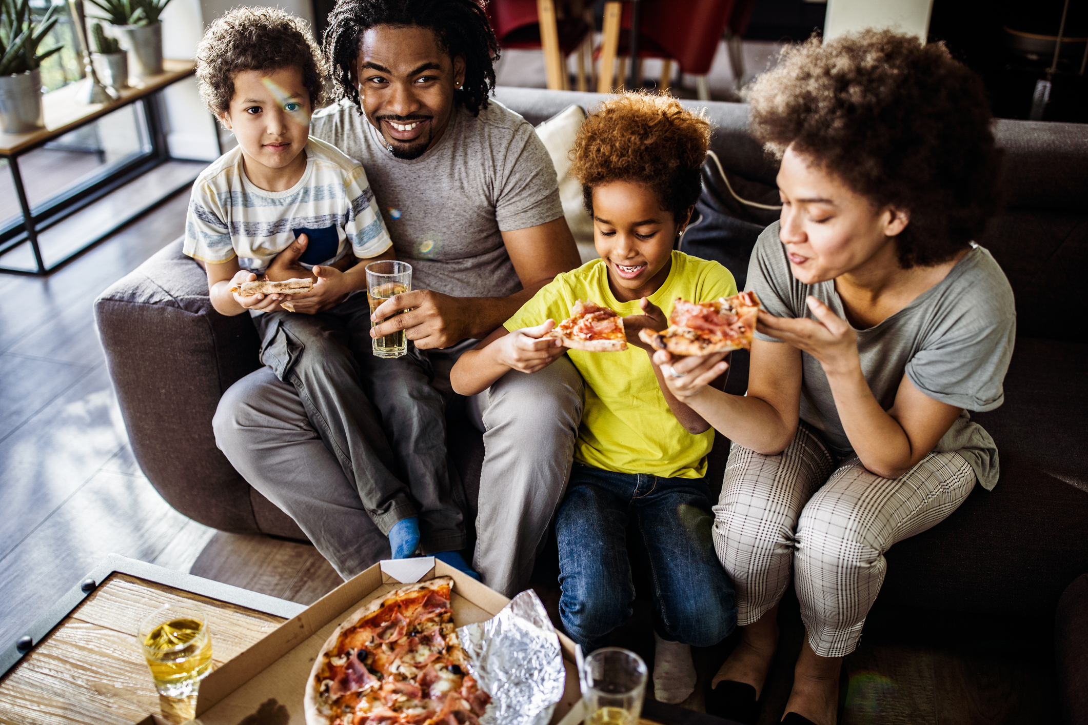 Above view of happy black family eating pizza at home.