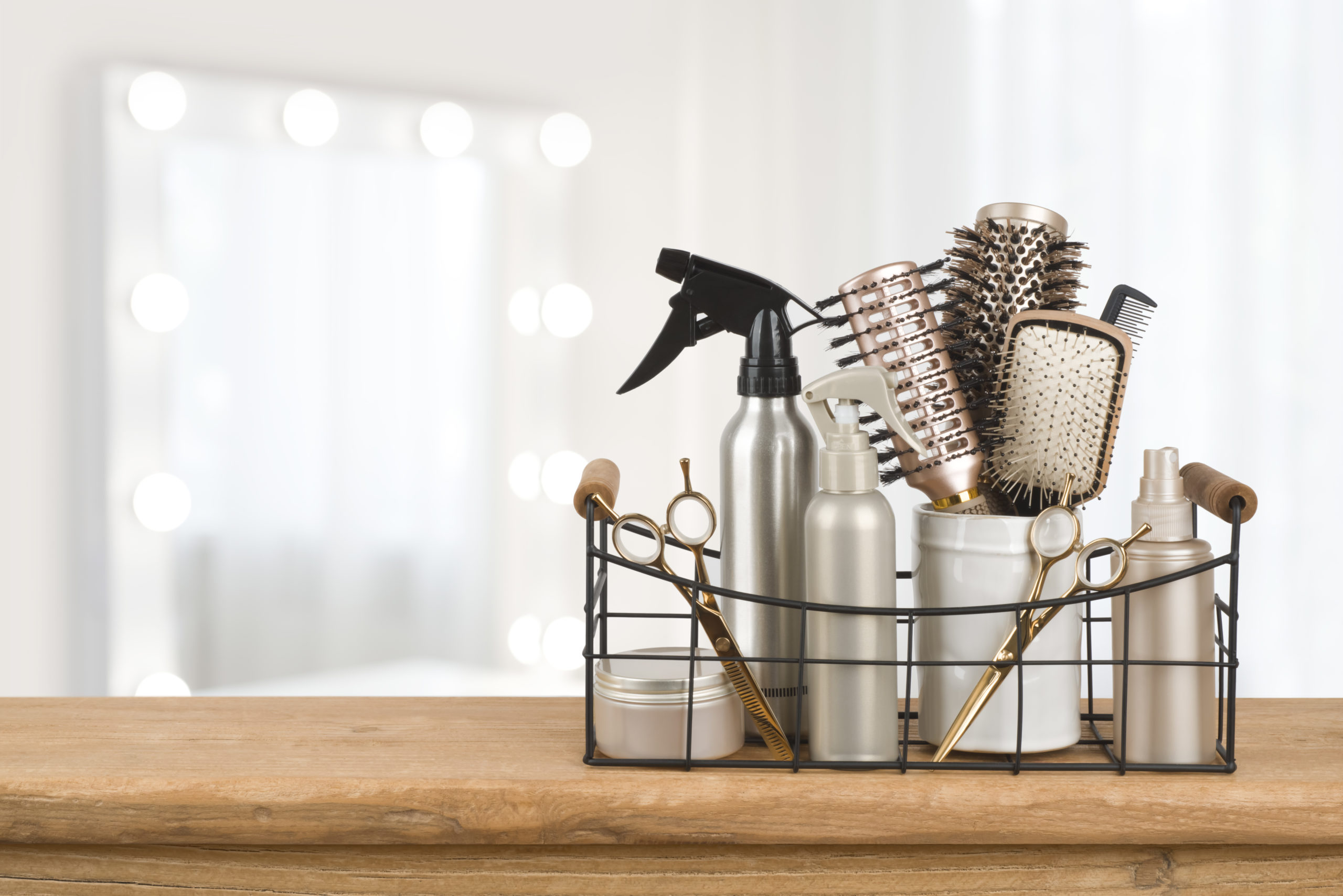 Hairdresser tools on wooden table with blurred beauty salon background