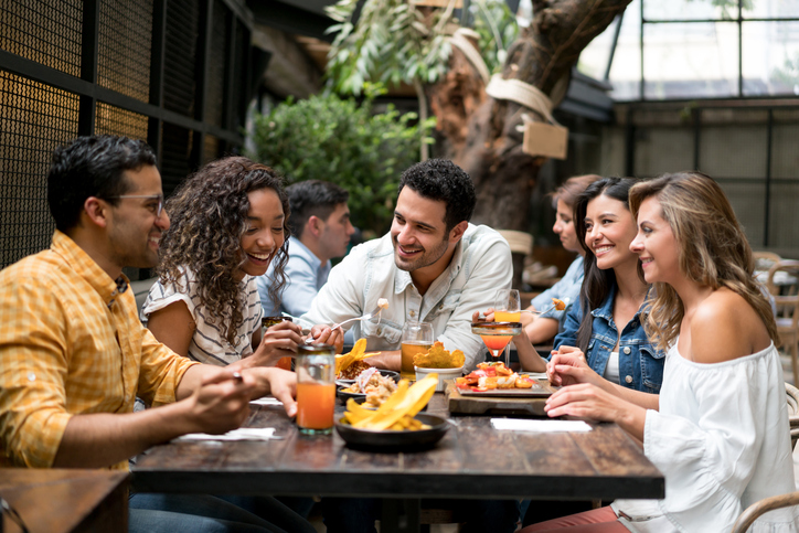 Happpy group of friends having dinner together at a restaurant